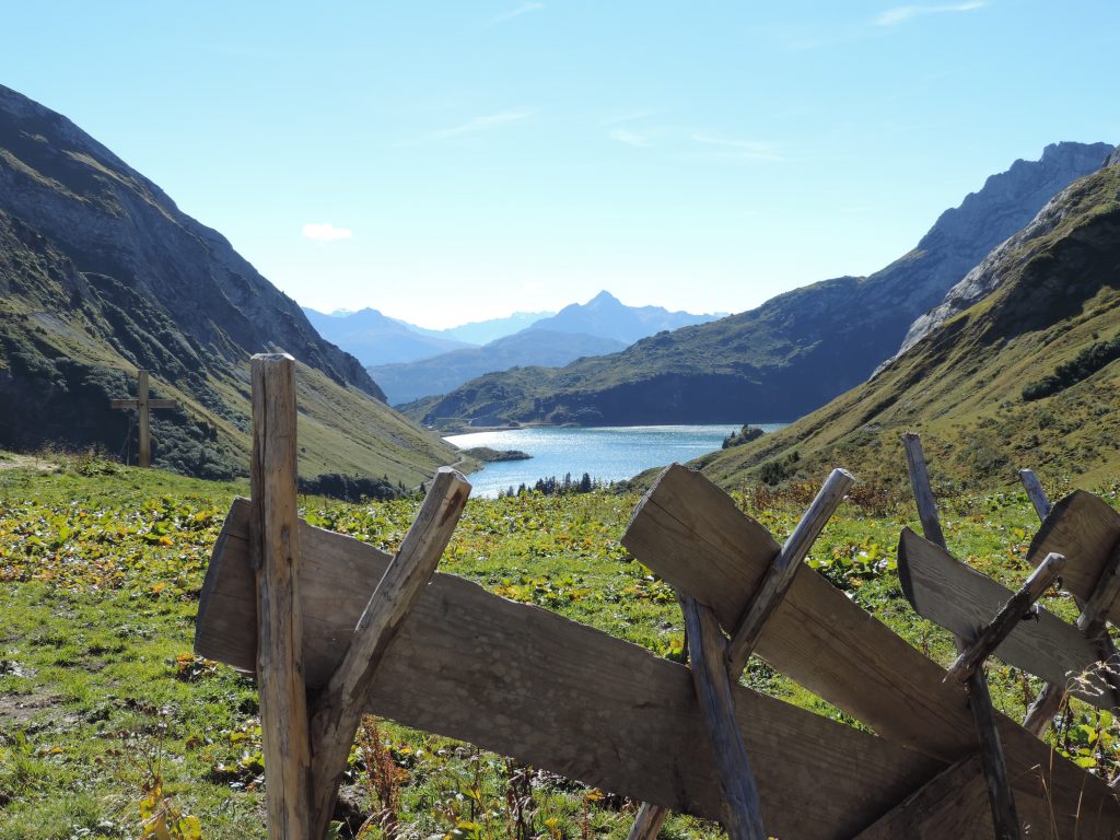 Ein toller Blick auf die majestätische Berglandschaft des Arlbergs, kombiniert mit dem ruhigen, klaren Wasser eines Bergsees, der die Schönheit der Natur widerspiegelt.